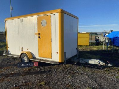 une photo d'une remorque garée sur un terrain en terre battue