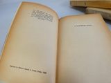 un livre ouvert posé sur une table à côté d'une pile de livres