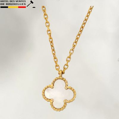 un collier en or orné d'un pendentif en forme de fleur blanche