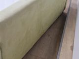 a bed with a green cover on it in a room
