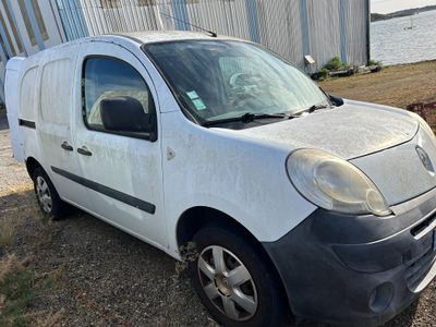 une photo d'une camionnette blanche garée devant un immeuble
