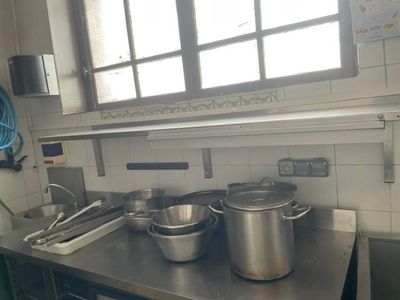pots and pans sit on a stainless steel counter in a kitchen