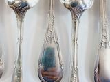 five spoons that are sitting on a table