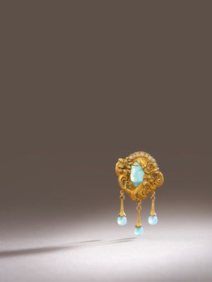 a close up of a gold and turquoise broochle broochle