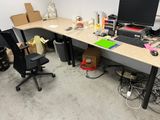 a desk with a computer and a chair in a room