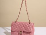 a pink chanel bag sitting on top of a white table