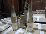 two bottles of wine sitting on a table in front of boxes
