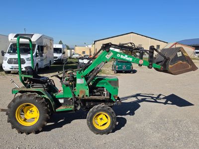 a green tractor with a bucket on the back of it
