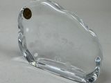 a clear glass object with a gold button on it