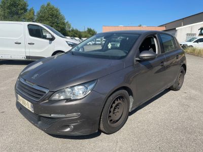 La voiture grise est garée sur le parking, à côté de la camionnette blanche.