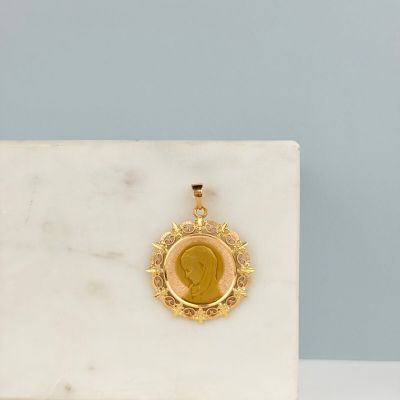 un gros plan sur un pendentif en or représentant une femme