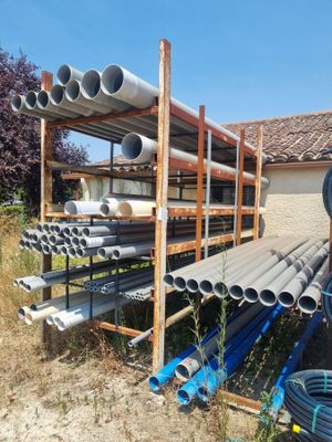many pipes that are stacked on a rack in the yard