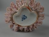 a white vase with a blue flower on it