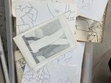 a box full of drawings on the floor next to a person