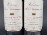 two bottles of red wine sitting next to each other on a table