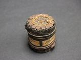 a small metal container with coins in it on a table