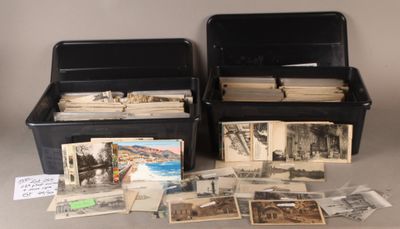 deux boîtes noires remplies de vieilles photos posées sur une table
