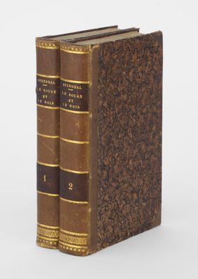 deux livres posés l'un sur l'autre sur une surface blanche