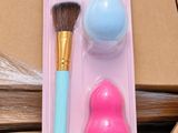 a pink and blue brush and a blue sponge on a cardboard box