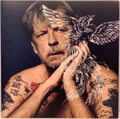une image représentant un homme tatoué tenant un oiseau