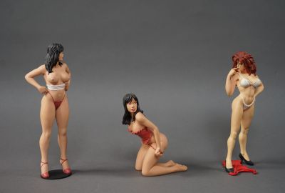 trois figurines représentant une femme assise par terre