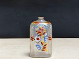 a small glass bottle with a colorful design on it