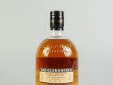 une bouteille de whisky single malt The Glenrothes posée sur une surface blanche