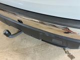 the rear end of a white truck with a chrome bumper