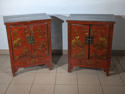 two red cabinets with oriental designs on them on a tiled floor