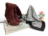 deux paires de bottes et une écharpe posées sur une table, à côté d'une fleur