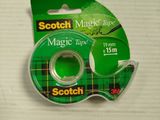 un rouleau de ruban adhésif « Scotch Magic » sur une surface blanche