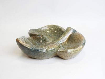 a small bowl with a spoon in it on a white surface