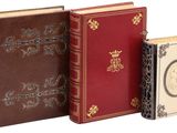 trois livres posés les uns à côté des autres sur une surface blanche
