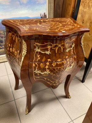 a small chest of drawers in a room with a painting on the wall behind it