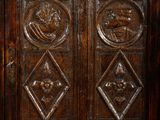 a close up of a wooden cabinet with carvings on the doors