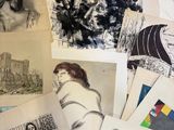 many drawings and pictures of people are on a table