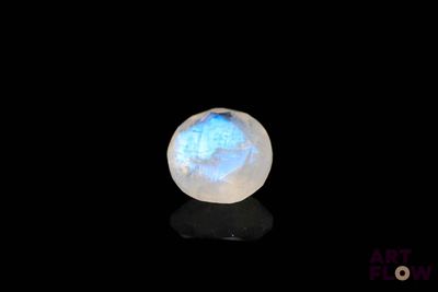 an image of a white and blue glass ball on a black surface