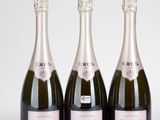 trois bouteilles de champagne posées les unes à côté des autres sur une table
