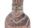 a small vase with a face on it on a white surface