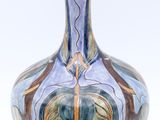 a blue and brown vase on a white surface