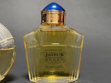 two bottles of perfume sitting next to each other on a table