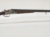 un fusil avec un canon en bois et un socle en plastique transparent