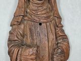 a wooden statue of a woman holding a basket and a basket
