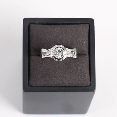 un gros plan d'une bague dans un écrin noir sur fond blanc
