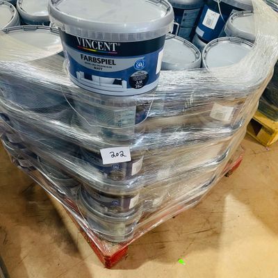 many cans of paint sitting on a pallet in a store