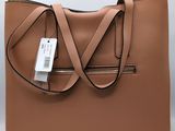an image of a tan leather handbag with a tag on it