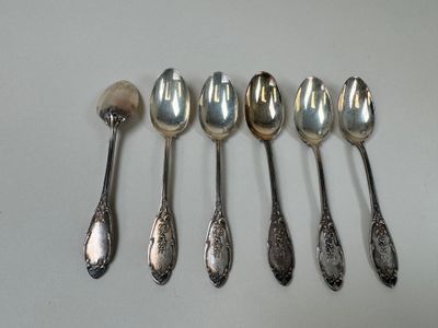 six spoons are lined up in a row on a table