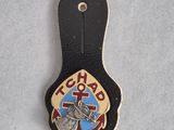 a close up of a badge on a black leather keychain