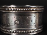 a close up of a silver ring on a black surface