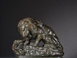 an image of a bronze statue of a lion on a rock